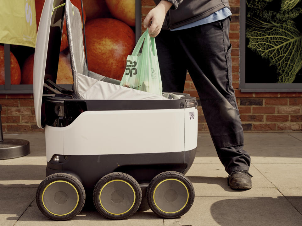 Un empleado carga un pedido en un robot de Starship afuera de una tienda en Milton Keynes, Inglaterra, el 16 de abril de 2020. (Ben Quinton/The New York Times)