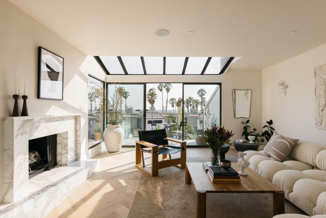  A neutral living room with herringbone flooring and a marble fireplace 