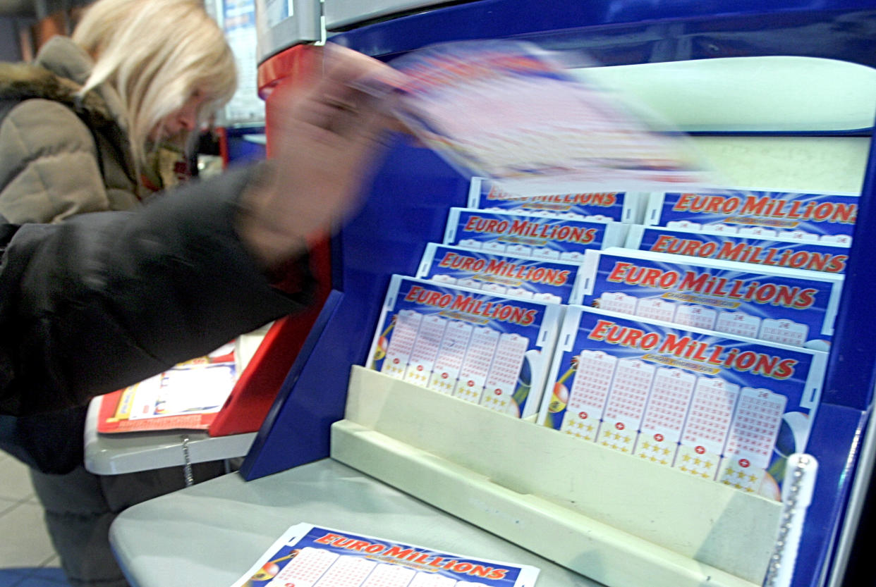 A customer picks up a Loto ticket in a Paris loto shop  Friday Jan. 13, 2006. Thousands of players are buying Euromillion tickets hoping to win the 103 million  Euros ($124,156,000) bonus on Friday's draw. (AP Photo/Remy de la Mauviniere)