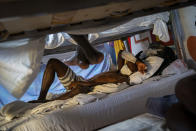 Hady Baye, 31, rests in a bunk bed at the Modern Christian Mission Church in Fuerteventura, one of the Canary Islands, Spain, on Saturday, Aug. 22, 2020. The Modern Christian Mission is the main shelter for rescued migrants on the island of Fuerteventura. Some 4,000 migrants have reached the Canaries so far this year, the most in over a decade, raising alarm at the highest levels of the Spanish government. (AP Photo/Emilio Morenatti)