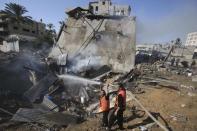 Palestinian firefighters extinguish a fire following what witnesses said was an Israeli air strike on a house, in Khan Younis in the southern Gaza Strip July 29, 2014. REUTERS/Ibraheem Abu Mustafa