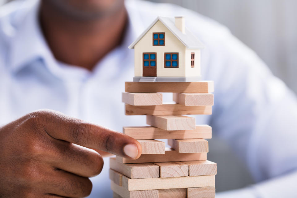 Close-up Of A Person Hand Holding Blocks With Miniature House