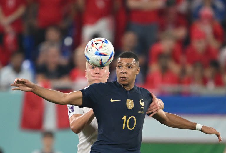 26 November 2022, Qatar, Doha: France's Kylian Mbappe (front) and Denmark's Rasmus Kristensen battle for the ball during the FIFA World Cup Qatar 2022 Group D soccer match between France and Denmark at Stadium 974. Photo: Robert Michael/dpa