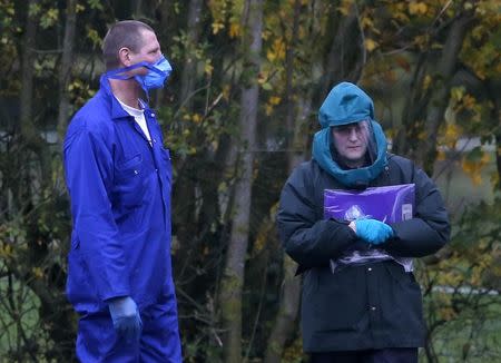 Experts wearing protective suits are seen at a duck farm in Nafferton, northern England November 17, 2014. REUTERS/Phil Noble