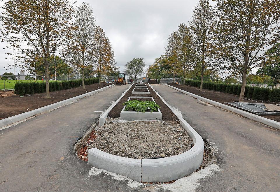 Work on the Sea Street entrance of Mount Wollaston Cemetery in Quincy includes new granite planters and maple trees.