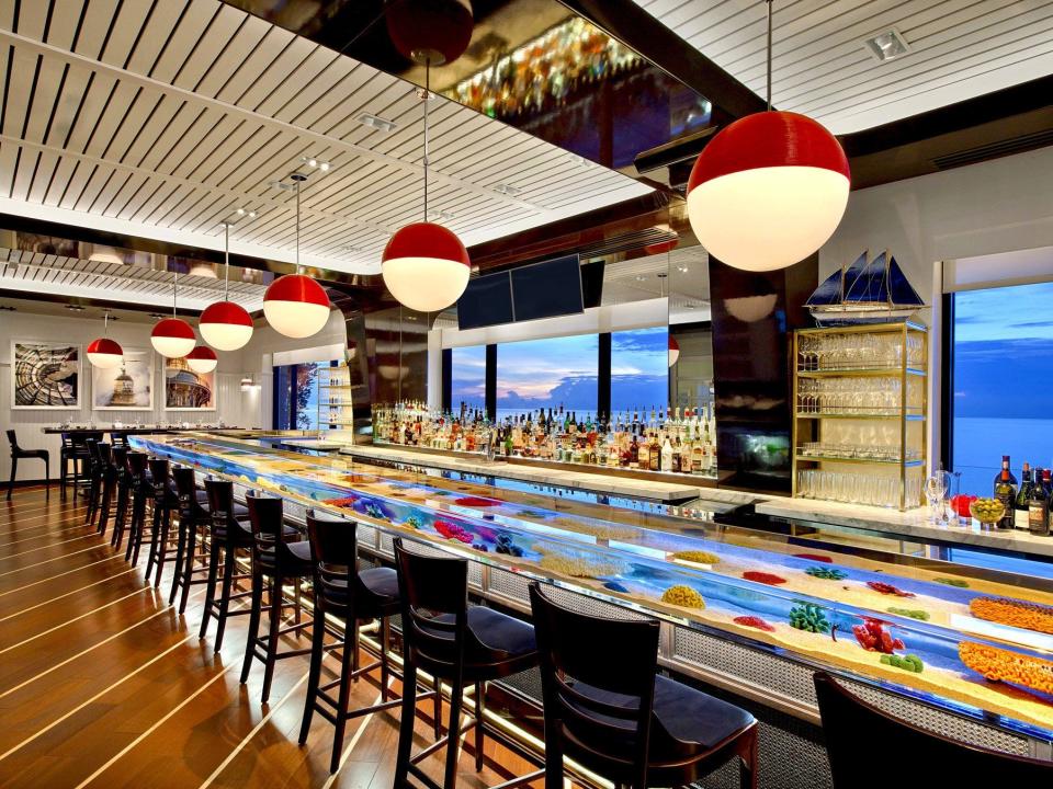 At the oceanfront Seafood Bar at The Breakers, guests are served their meals and drinks on top of a tropical fish-filled aquarium bar top. Photo courtesy The Breakers.