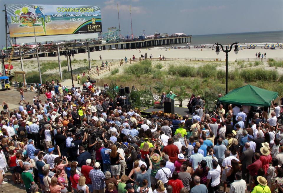 New Jersey Gov. Chris Christie, center second right, and Sen. Stephen M. Sweeney, center right, D-West Deptford, look on in Atlantic City, N.J., Monday, July, 24, 2012, as singer Jimmy Buffett, center at podium, announces that he is teaming up with Resorts Casino Hotel to bring one of his Margarativille casino-entertainment complexes to Atlantic City. The project will be built as an addition to the Resorts Casino Hotel. (AP Photo/Mel Evans)