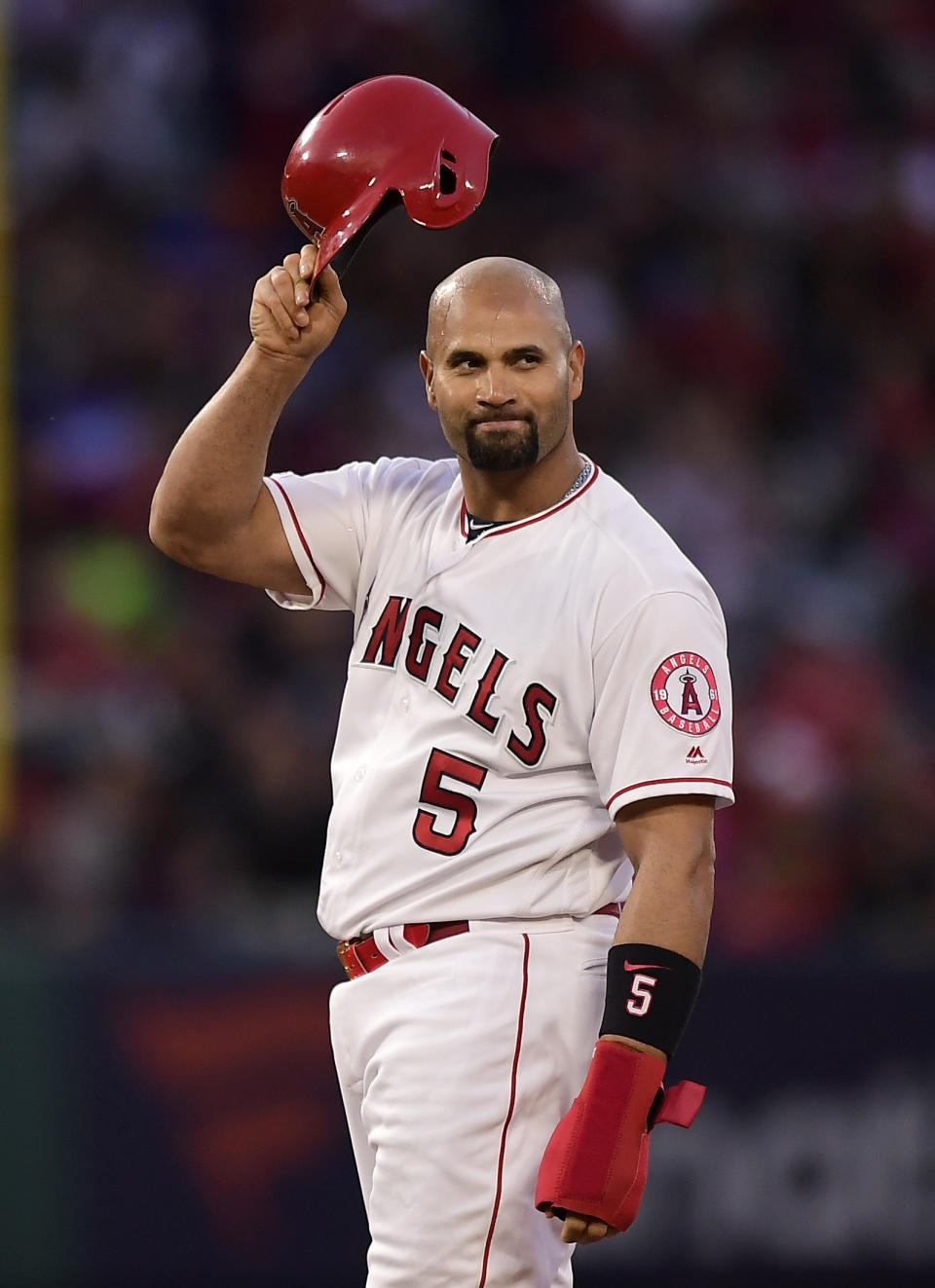 Los Angeles Angels' Albert Pujols tips his helmet to fans after hitting an RBI double during the third inning of a baseball game against the Seattle Mariners Saturday, April 20, 2019, in Anaheim, Calif. With that RBI, Pujols tied Babe Ruth for 5th place on the all-time RBI list with 1,992. (AP Photo/Mark J. Terrill)