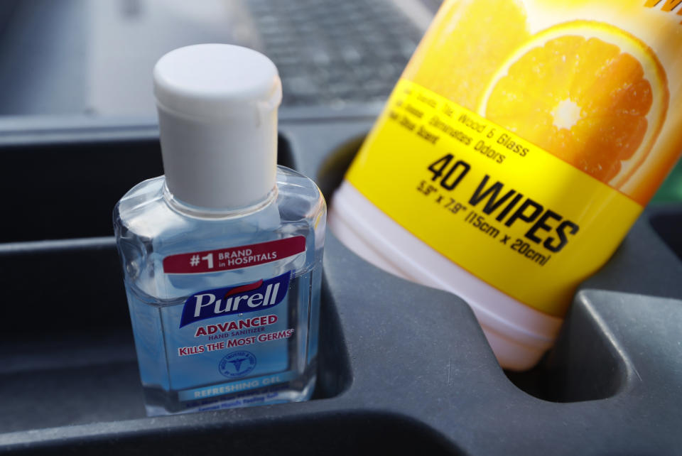 In this Tuesday, March 17, 2020, photo hand sanitizer and cleaner wipes sit in a cart as Des Moines Area Religious Council food pantry worker Patrick Minor passes out food at a senior center in Des Moines, Iowa. The Associated Press has found that the critical shortage of testing swabs, protective masks, surgical gowns and hand sanitizer can be tied to a sudden drop in imports of medical supplies. (AP Photo/Charlie Neibergall)