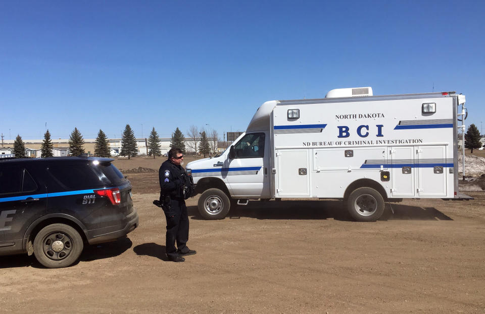 In this Wednesday, April 3, 2019 photo, state and local police search a field in Manton, N.D., about half a mile from a business where an owner and three employees were found dead. Authorities on Thursday said they were looking for "potential evidence" related to the deaths discovered Monday at RJR Maintenance and Management in Mandan, a city just outside Bismarck. Police haven't yet identified a suspect. (AP Photo/ Blake Nicholson)