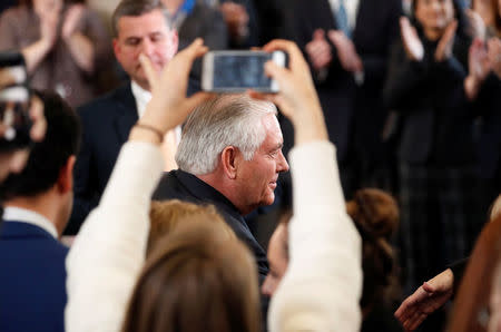 A State Department worker holds up her phone to get a photo of U.S. Secretary of State Rex Tillerson leaving the State Department for the last time in Washington, U.S., March 22, 2018. REUTERS/Kevin Lamarque