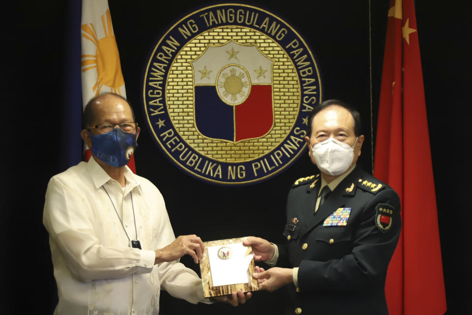 In this handout photo provided by the Department of National Defense Public Affairs Office (PAO), Philippine Defense Secretary Delfin N. Lorenzana, left, exchanges momento with his Chinese counterpart General Wei Fenghe during his visit at the Department of National Defense in Quezon city, Philippines, Friday Sept. 11, 2020. The two discussed ways in responding to the COVID-19 pandemic, revisited the 2004 Philippines-China Memorandum of Understanding (MOU) on Defense Cooperation and also issues on the South China Sea. (Department of National Defense PAO via AP)