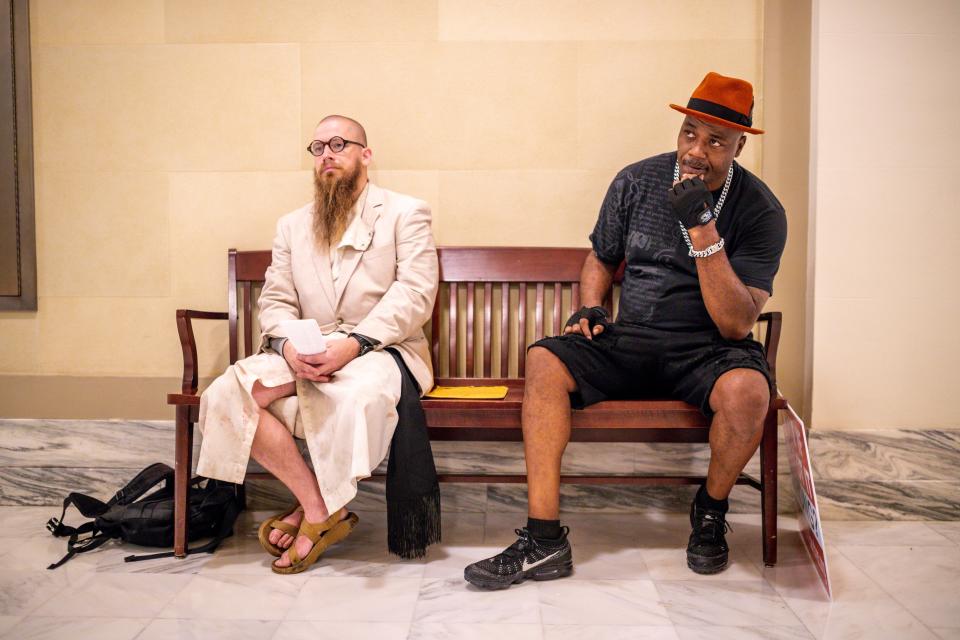 The Rev. Jeff Hood, left, sits outside Gov. Kevin Stitt's office after walking to the state Capitol from McAlester to deliver a letter from death row inmate Anthony Sanchez. Waiting with him is former death row inmate Paris Powell.