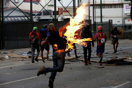 A demonstrator throws a petrol bomb at a rally during a strike called to protest against Venezuelan President Nicolas Maduro's government in Caracas. REUTERS/Andres Martinez Casares