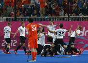 Netherlands' Valentin Verga (front) reacts as Germany's team players celebrate winning during their men's gold medal hockey match at the Riverbank Arena at the London 2012 Olympic Games August 11, 2012. REUTERS/Suzanne Plunkett (BRITAIN - Tags: SPORT OLYMPICS FIELD HOCKEY) 