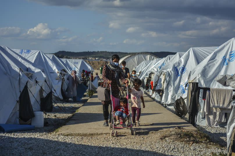 Migrants walk after a rainstorm at the Kara Tepe refugee camp, on the northeastern Aegean island of Lesbos, October 2020