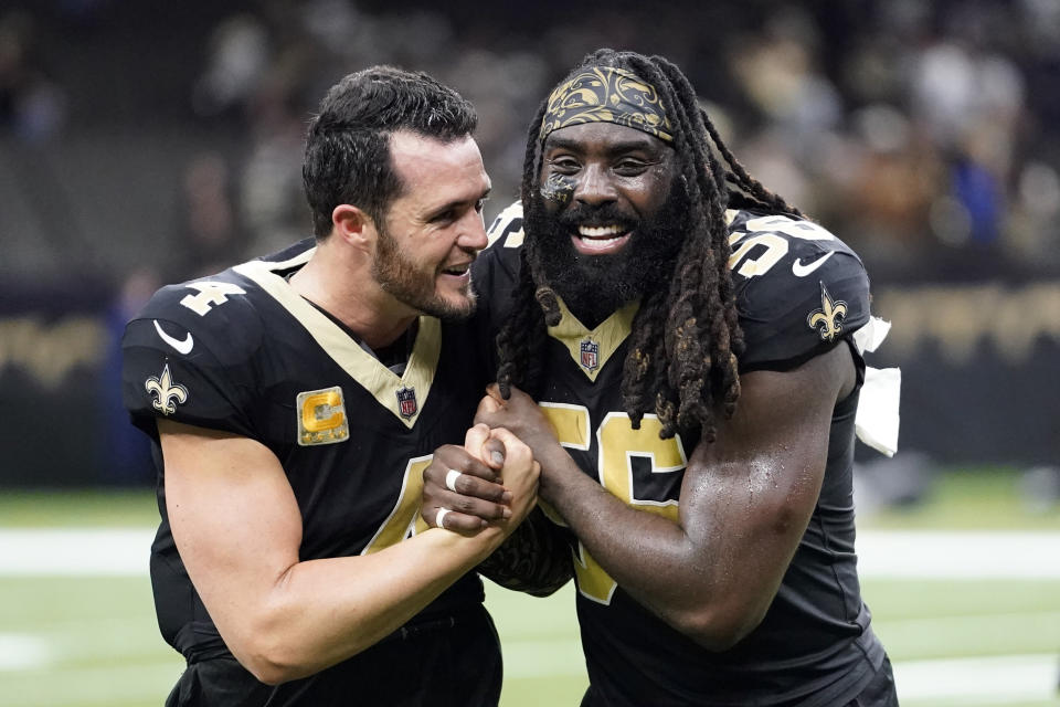 New Orleans Saints quarterback Derek Carr, left, celebrates with linebacker Demario Davis (56) after a win over the Chicago Bears in an NFL football game in New Orleans, Sunday, Nov. 5, 2023. (AP Photo/Gerald Herbert)
