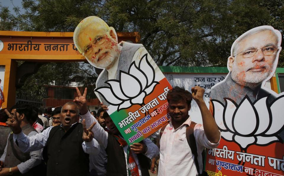 Bharatiya Janata Party supporters raise cutouts of Indian Prime Minister Narendra Modi as they celebrate winning seats in the state of Uttar Pradesh in Lucknow, India, Saturday, March 11, 2017. India's governing Hindu nationalist party is heading for major victories in key state legislature elections that are seen as a referendum on Modi's nearly 3-year-old rule. (AP Photo/Rajesh Kumar Singh)