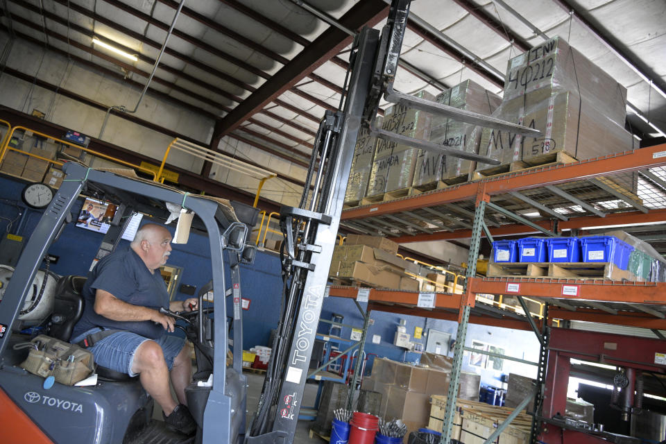 Employee John Marra moves pallets containing a shipment of 9mm SUB2000 rifles awaiting shipment to Ukraine at the KelTec gun manufacturing facility on Thursday, March 17, 2022, in Cocoa, Fla. The Florida-based company decided to donate the weapons to Ukraine's nascent resistance movement after it could no longer locate a longtime civilian customer in Odessa that had ordered $200,000 worth of rifles before Vladimire Putin's invasion. (AP Photo/Phelan M. Ebenhack)