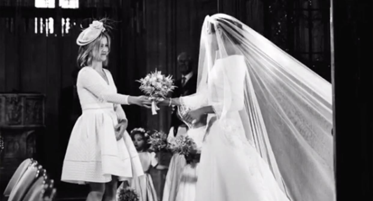 Clara Lougran hands Meghan a bouquet of flowers at the royal wedding last year