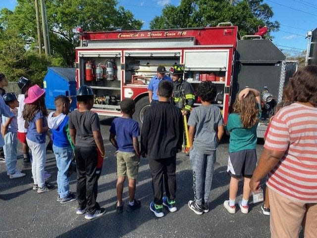 Representatives from the Melbourne Fire Department share information about fire safety with children who attend afterschool sessions at Aspiration Academy.