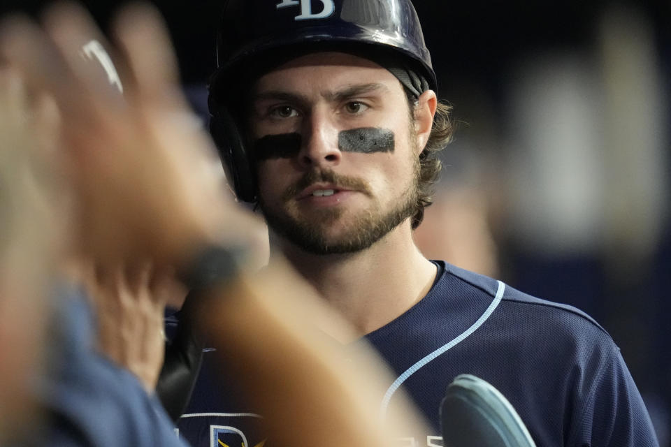 Tampa Bay Rays' Josh Lowe is congratulated by teammates after he scored on a base hit by Curtis Mead in the seventh inning during Game 2 in an AL wild-card baseball playoff series against the Texas Rangers, Wednesday, Oct. 4, 2023, in St. Petersburg, Fla. (AP Photo/John Raoux)