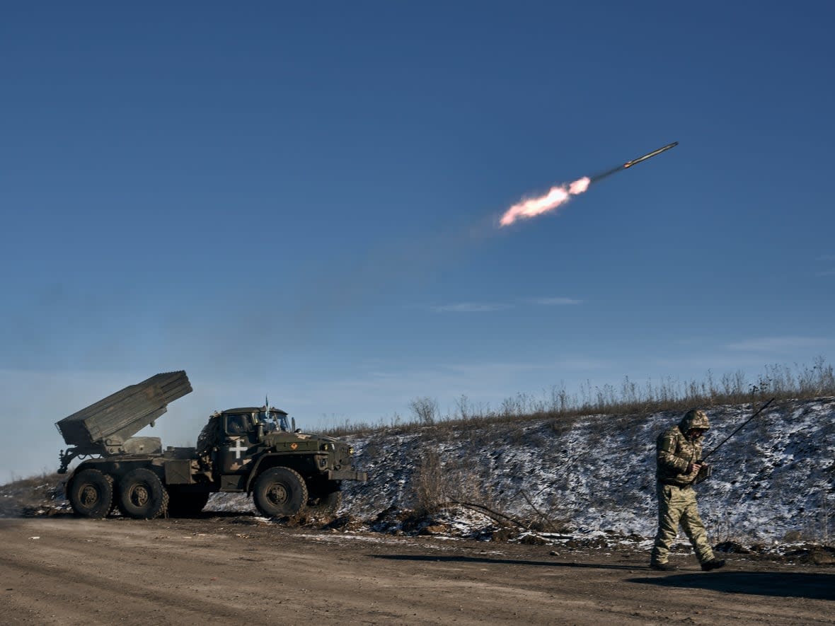 Ukrainian forces use a Grad multiple rocket launcher to fire rockets at Russian positions at the front line near Soledar, Donetsk region, Ukraine, on Wednesday. (Libkos/The Associated Press - image credit)