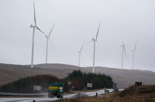 Wind turbines on a hill next to a road