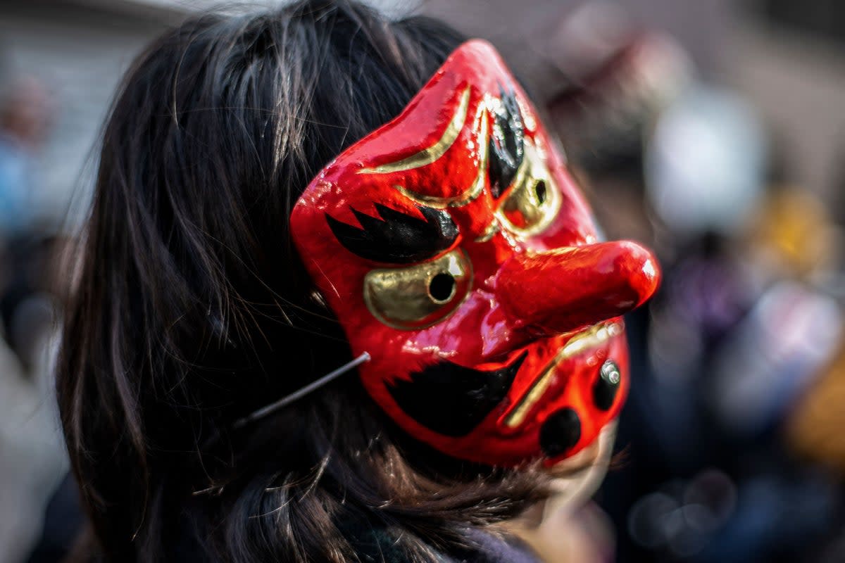 A woman wearing a Tengu mask takes part in the Tengu Parade, a traditional event held to drive away evil spirits and to bring good luck (AFP via Getty Images)