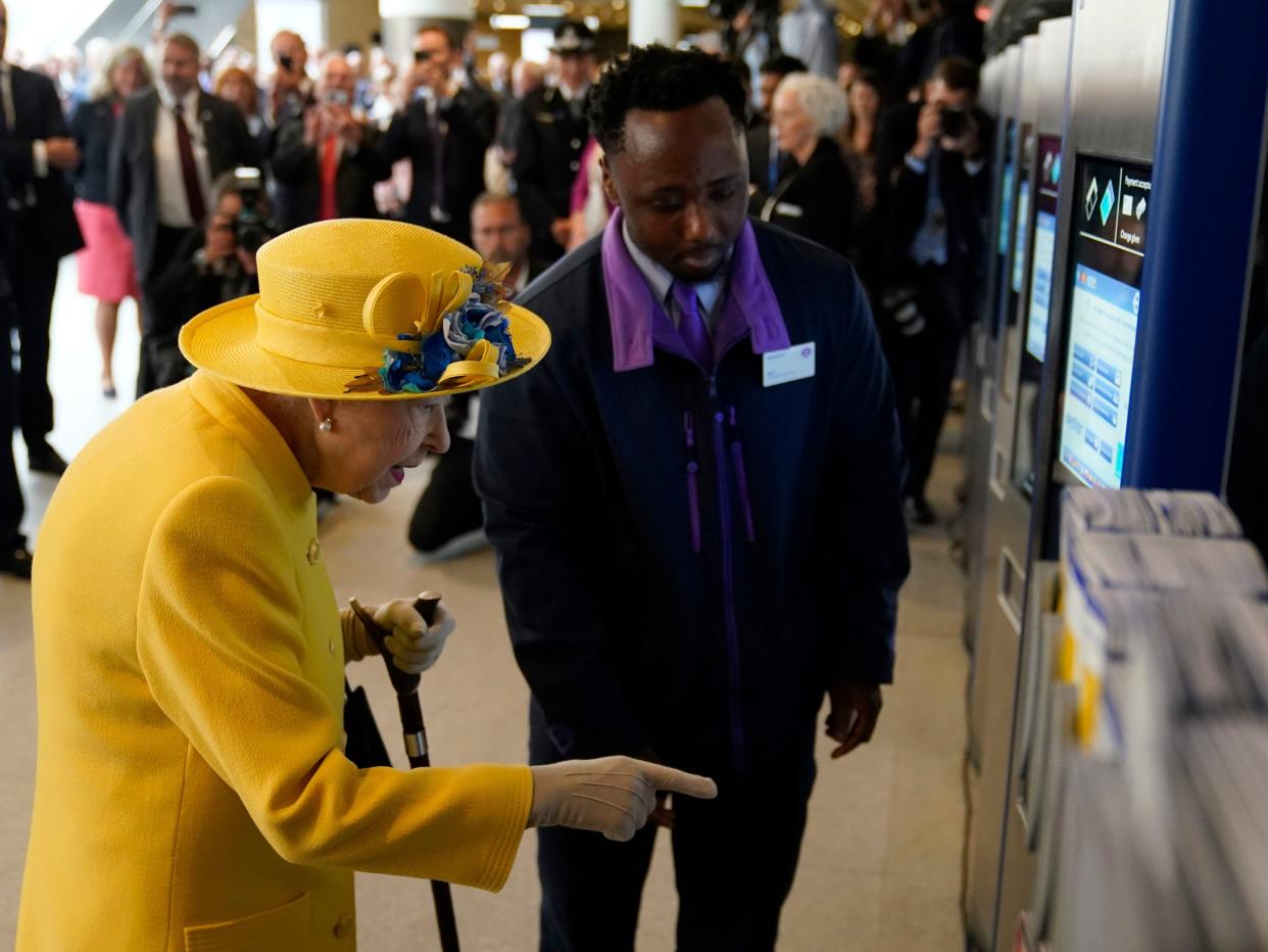 Queen Elizabeth II using an oyster card machine as she attends the Elizabeth line's official opening at Paddington Station.