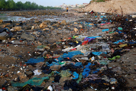 A woman walks at the beach covered with plastic waste in Thanh Hoa province, Vietnam June 4, 2018. REUTERS/Kham