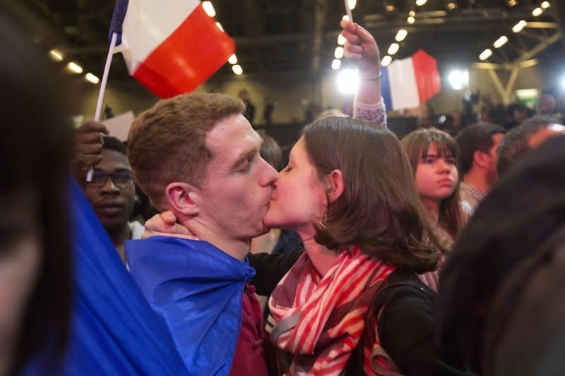 法國總統大選23日進行第一輪投票，中間派候選人馬克宏（Emmanuel Macron）的支持者歡欣親吻（AP）