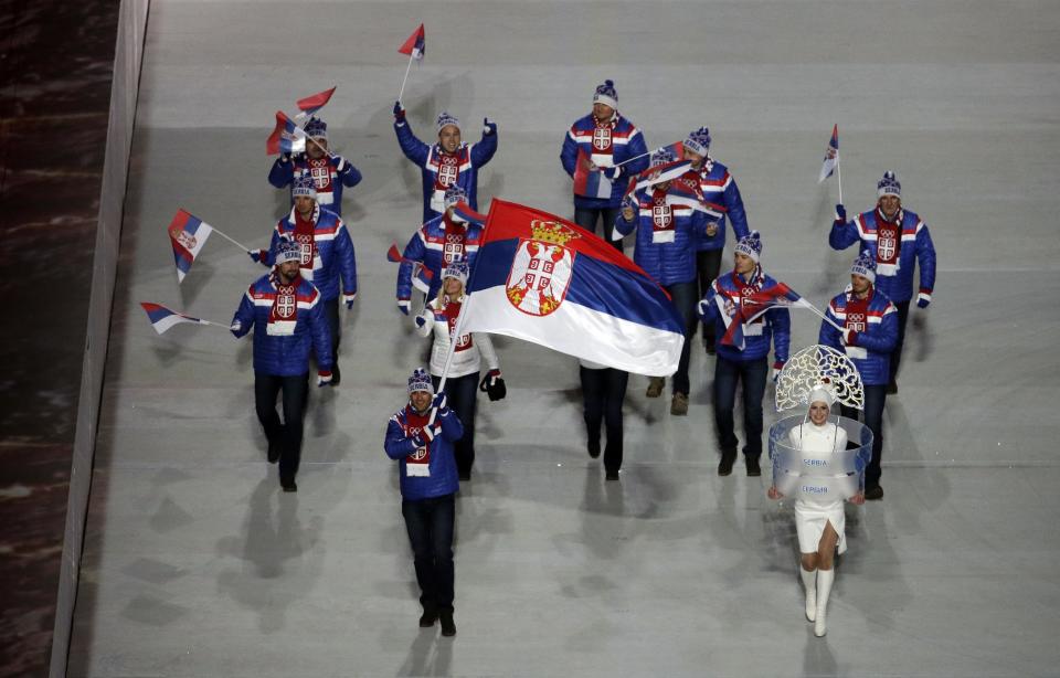 Milanko Petrovic of Serbia holds his national flag and enters the arena with teammates during the opening ceremony of the 2014 Winter Olympics in Sochi, Russia, Friday, Feb. 7, 2014. (AP Photo/Charlie Riedel)