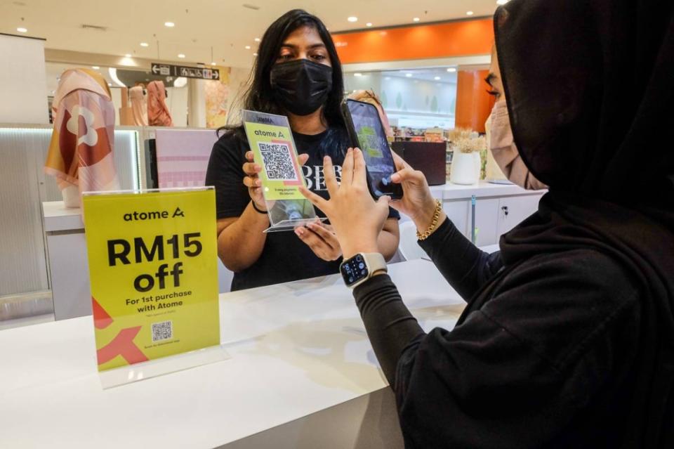 A customer scans a QR code for the Atome app to make a cashless payment at the shop in Shah Alam June 23, 2022. — Picture by Yusof Mat Isa