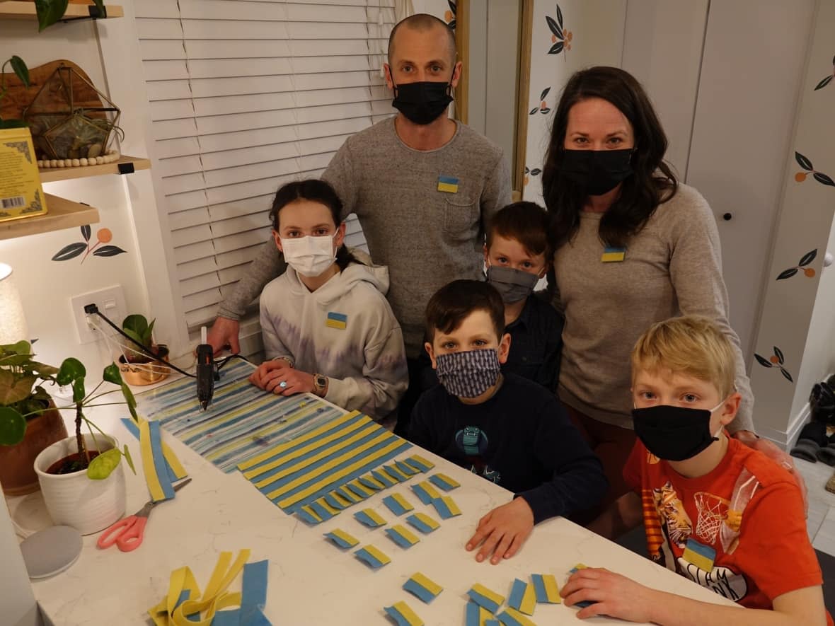 The Lewchuk family felt heartbroken watching the invasion of Ukraine unfold, but have found a creative way to hopefully make a difference. From left to right: Sophie, Simon, Ollie (seated), Ben, Ashley and Sam. (Giacomo Panico/CBC - image credit)
