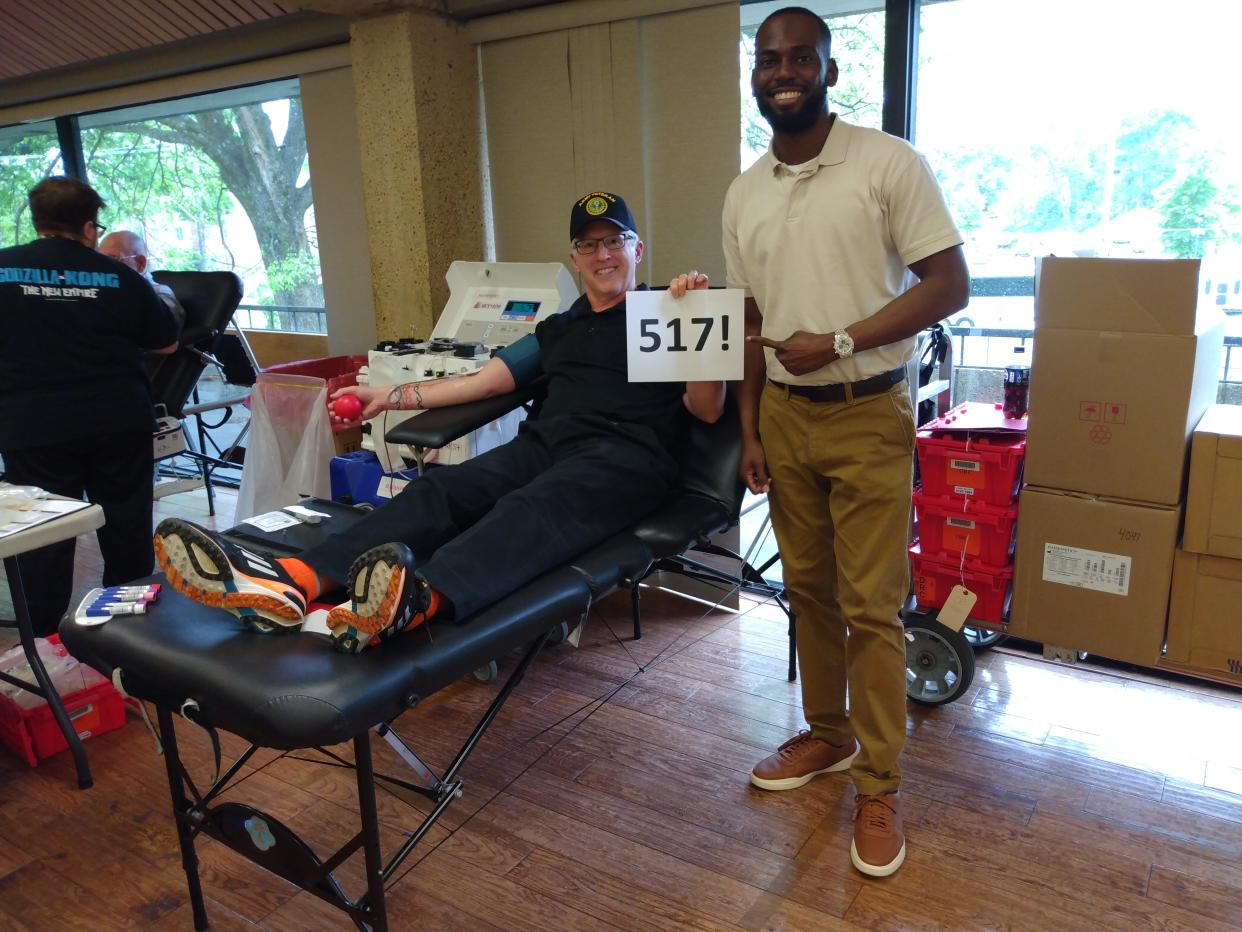 Shaun Brennan sits in a donor chair alongside Chris Ruffin Jr. during a blood drive at LeMoyne-Owen College on April 19, 2024. Brennan has donated blood, plasma or platelets 517 times and had Ruffin Jr., a sickle cell patient, autograph his 517 sign as a memento.