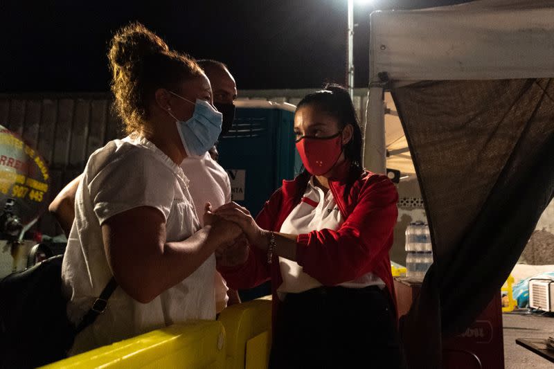 Sarah Bettache is comforted by a Red Cross member after seeing her brother Ahmed, 19, a migrant from Morocco, in the port of Arguineguin