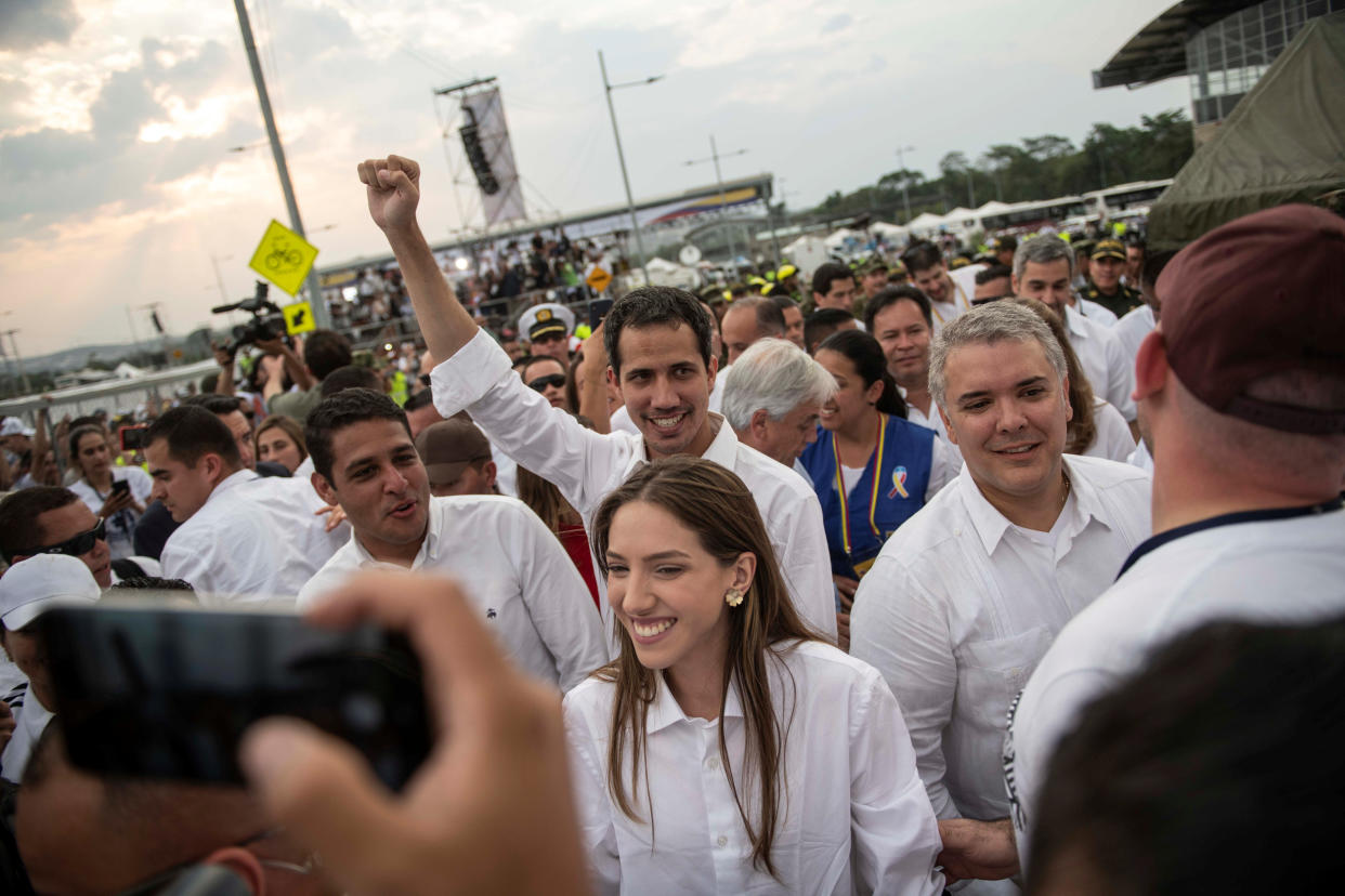 El presidente encargado de Venezuela, Juan Guaidó, saluda a la multitud junto a su esposa Fabiana Rosales en el concierto organizado por Richard Branson en Colombia el 22 de febrero de 2019 (Foto Marcelo Segura/Cortesía de la Presidencia de Chile via Reuters)