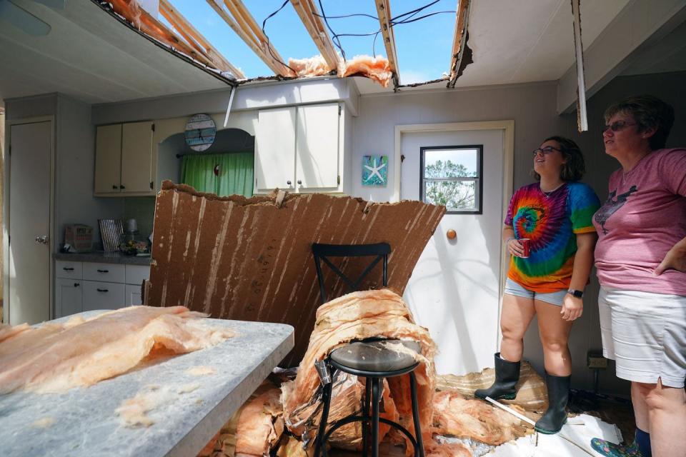 Hurricane Ian tore up roofs on homes, businesses and at least one hospital. <a href="https://www.gettyimages.com/detail/news-photo/andrea-barrios-and-her-daughter-hannah-look-over-her-news-photo/1243602908" rel="nofollow noopener" target="_blank" data-ylk="slk:Bryan R. Smith / AFP via Getty Images;elm:context_link;itc:0;sec:content-canvas" class="link ">Bryan R. Smith / AFP via Getty Images</a>