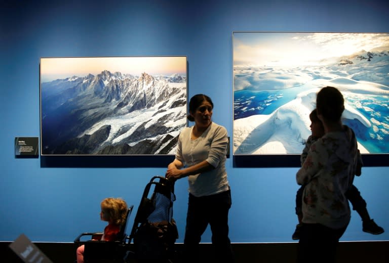People attend the "Extreme Ice" exhibit by US photographer James Balog at the Museum of Science and Industry in Chicago, Illinois