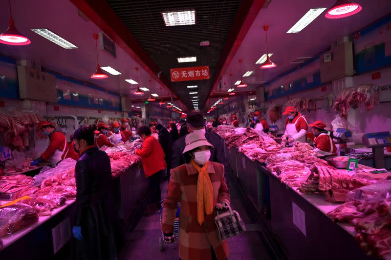 FILE PHOTO: Customers wearing face masks buy pork meat at the Xinfadi wholesale market, as the country is hit by an outbreak of the novel coronavirus disease (COVID-19), in Beijing