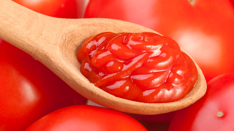Ketchup in spoon over tomatoes