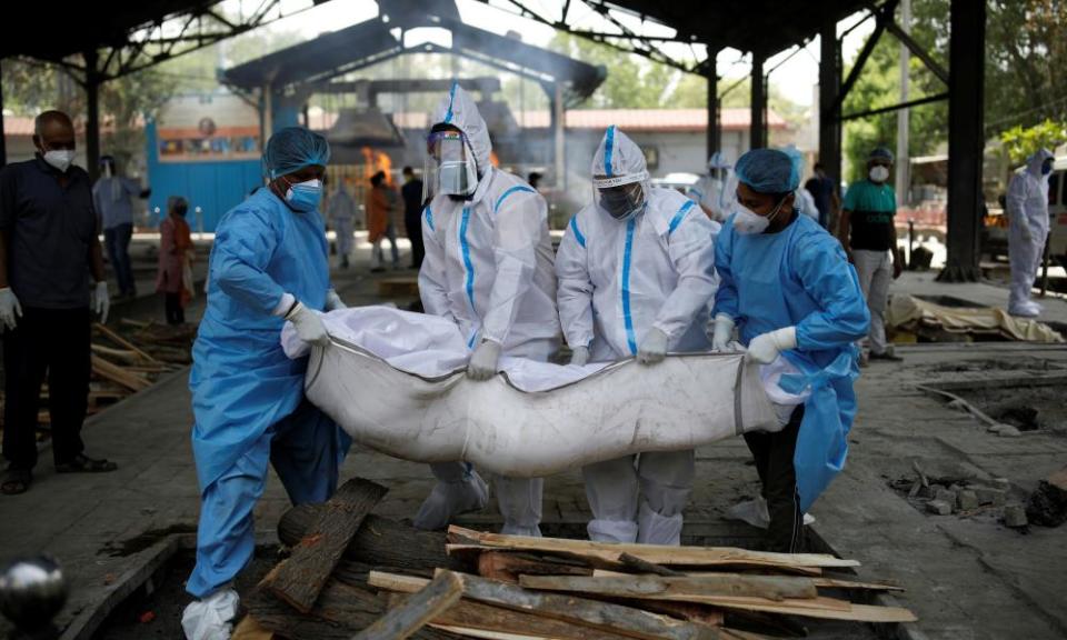 Health workers and relatives carry the body of a man who died from coronavirus disease, at a crematorium in New Delhi.