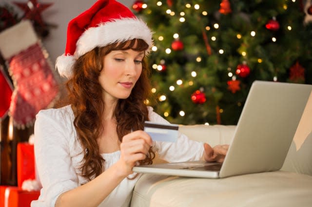 Redhead shopping online with laptop at christmas at home in the living room