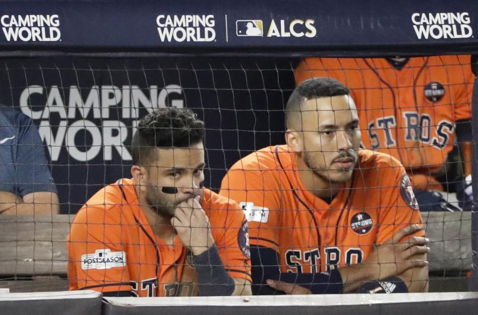 Houston Astros’ Jose Altuve and Carlos Correa watch from the dugout during the seventh inning of Game 5 of baseball’s American League Championship Series against the New York Yankees Wednesday, Oct. 18, 2017, in New York. (AP Photo/David J. Phillip)