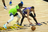 Minnesota Timberwolves forward Anthony Edwards (1) and Sacramento Kings guard Tyrese Haliburton (0) scramble for the ball during the first quarter of an NBA basketball game in Sacramento, Calif., Tuesday, April 20, 2021. (AP Photo/Randall Benton)