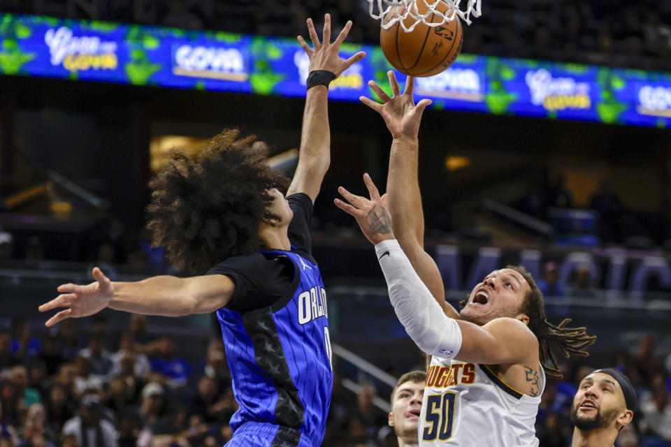 Denver Nuggets forward Aaron Gordon (50) shoots against Orlando Magic guard Anthony Black, left, during the first half of an NBA basketball game Wednesday, Nov. 22, 2023, in Orlando, Fla. (AP Photo/Kevin Kolczynski)