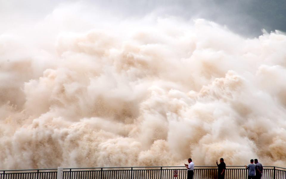 A huge wall of water slams into Jiyuan. The colour combination of yellow and white due to different sand content -  SplashNews.com/Splash News