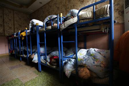 Children sleep in a dormitory at a kindergarten, a school for children of migrant workers, on the outskirts of Beijing November 8, 2013. REUTERS/Jason Lee