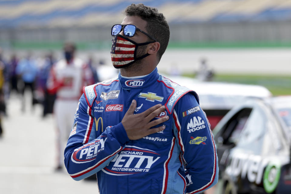 Bubba Wallace stands for the National Anthem before the start of a NASCAR Cup Series auto race Sunday, July 12, 2020, in Sparta, Ky. (AP Photo/Mark Humphrey)